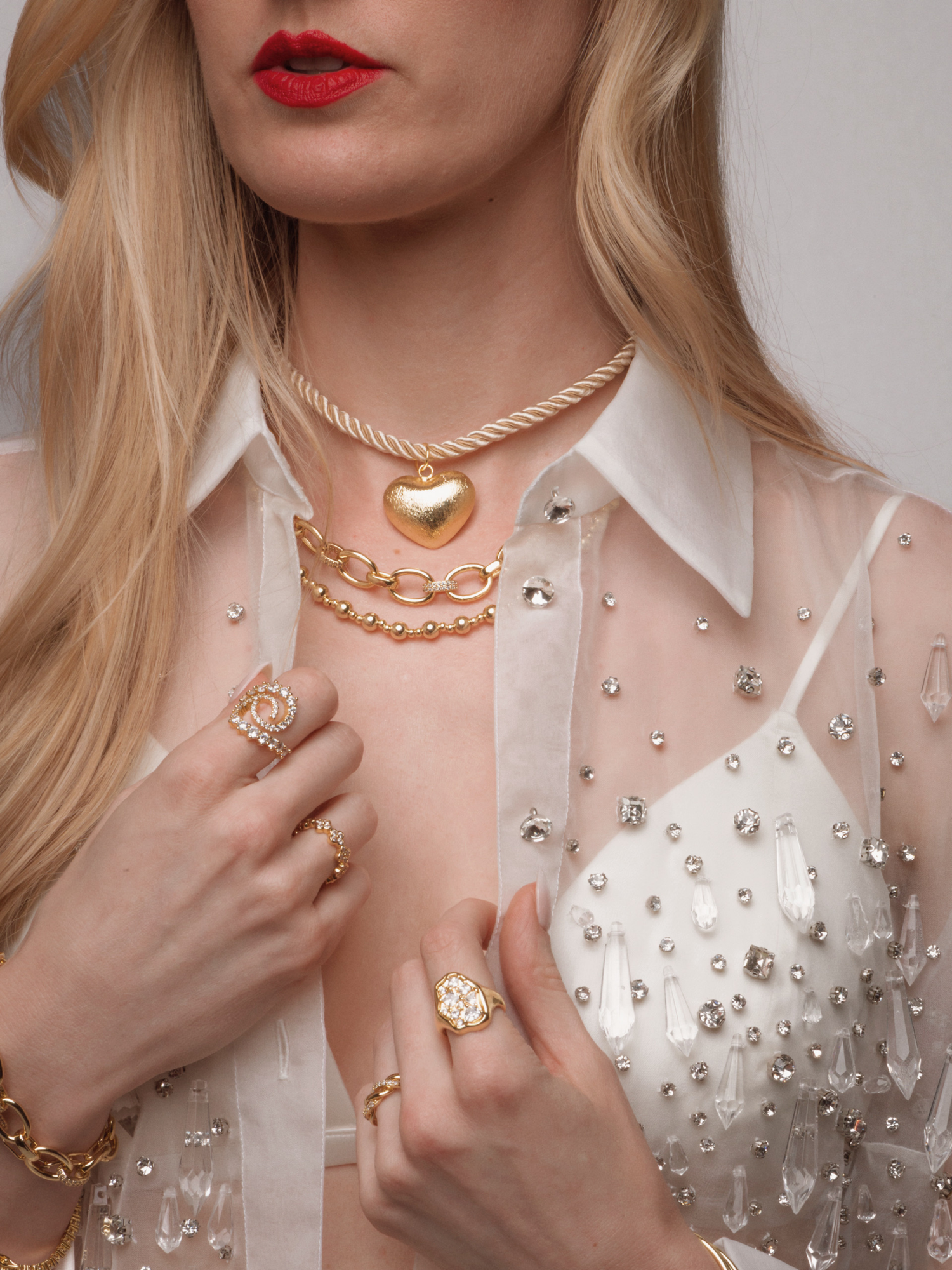 woman wearing gold necklaces hanging down her back and a low cut pink dress
